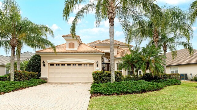 7244 Orchid Island Pl, Bradenton, FL 34202 - mediterranean / spanish home featuring stucco siding, decorative driveway, an attached garage, and a tile roof