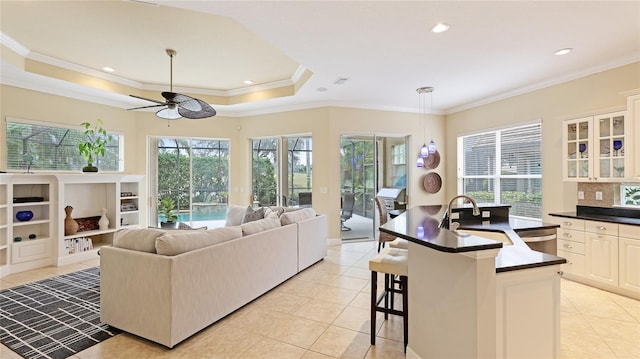7244 Orchid Island Pl, Bradenton, FL 34202 - living room with light tile patterned floors, ceiling fan, crown molding, recessed lighting, and a raised ceiling