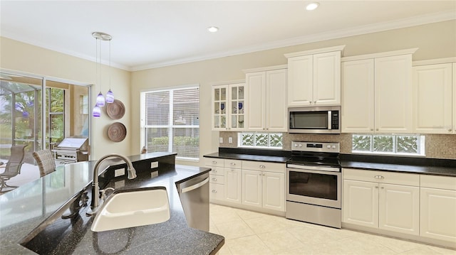 7244 Orchid Island Pl, Bradenton, FL 34202 - kitchen featuring stainless steel appliances, dark countertops, backsplash, plenty of natural light, and ornamental molding
