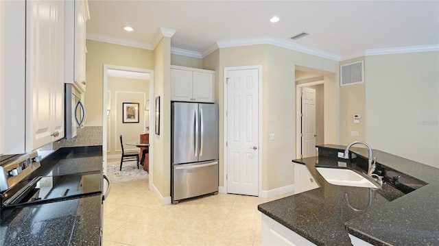 7244 Orchid Island Pl, Bradenton, FL 34202 - kitchen featuring appliances with stainless steel finishes, white cabinets, ornamental molding, dark stone counters, and light tile patterned floors