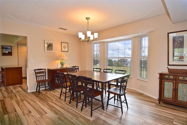 dining space with an inviting chandelier and light hardwood / wood-style flooring