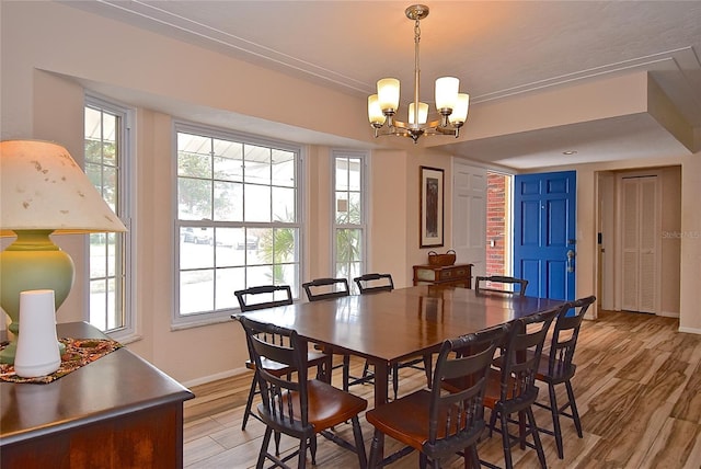 dining space with an inviting chandelier and light hardwood / wood-style flooring