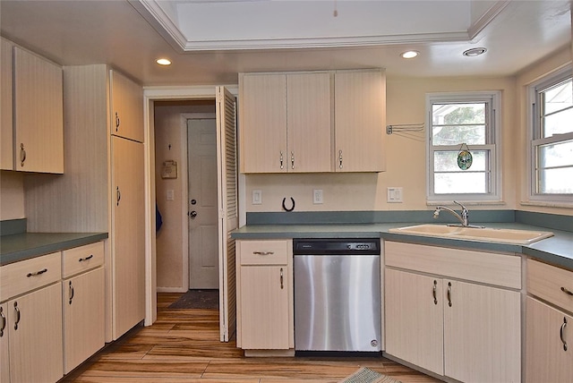 kitchen featuring stainless steel dishwasher, light hardwood / wood-style floors, sink, a tray ceiling, and crown molding