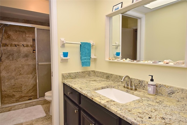 bathroom featuring tile patterned floors, toilet, vanity, and an enclosed shower