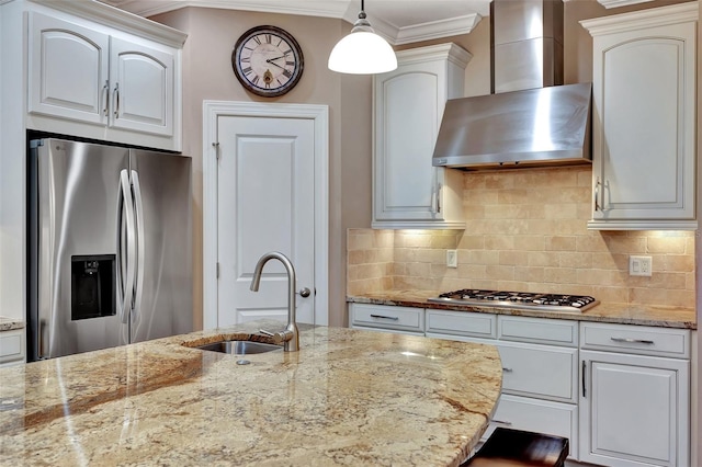 kitchen featuring wall chimney exhaust hood, sink, decorative light fixtures, stainless steel appliances, and white cabinets