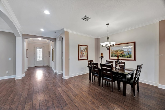 dining area featuring ornamental molding, dark wood-type flooring, and a chandelier