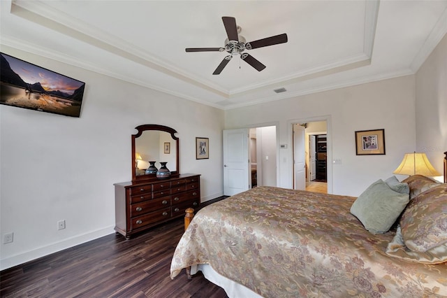 bedroom with ceiling fan, ornamental molding, a tray ceiling, and dark hardwood / wood-style flooring