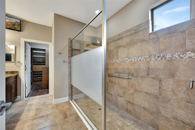 bathroom with a tile shower and vanity