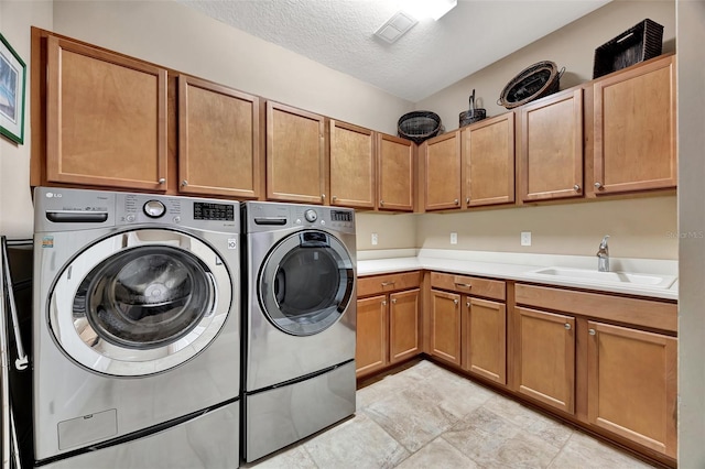 laundry room with cabinets, sink, a textured ceiling, and independent washer and dryer