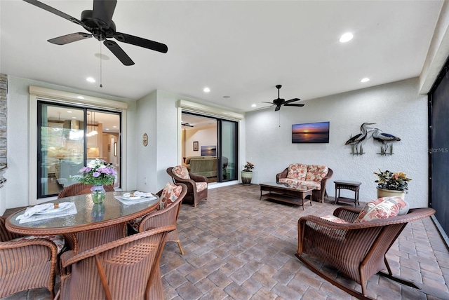 interior space featuring outdoor lounge area and ceiling fan