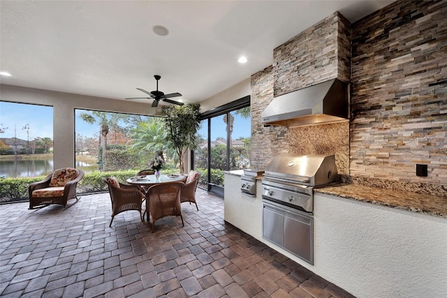 view of patio featuring a water view, area for grilling, grilling area, and ceiling fan