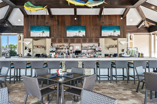 interior space featuring lofted ceiling with beams and wood walls