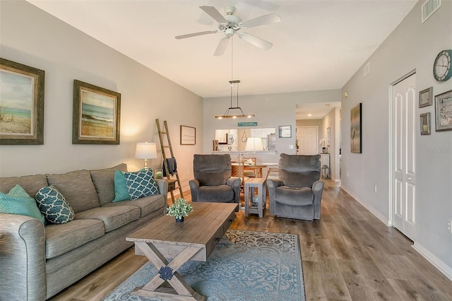 living room with ceiling fan and wood-type flooring