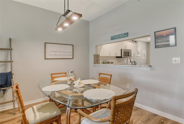 dining area with sink and light hardwood / wood-style flooring