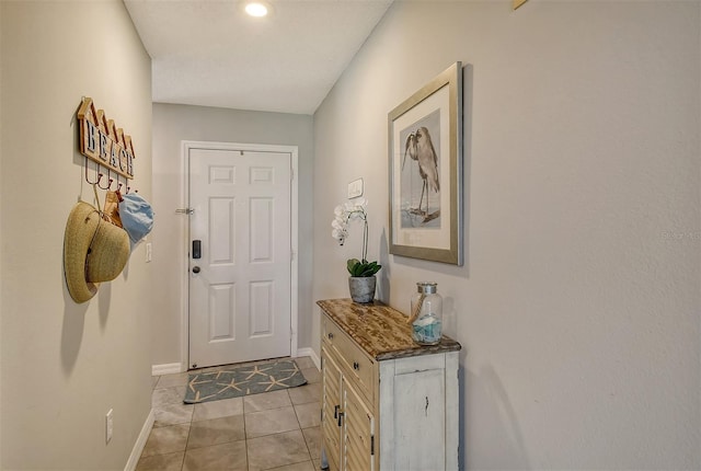 doorway to outside with light tile patterned floors