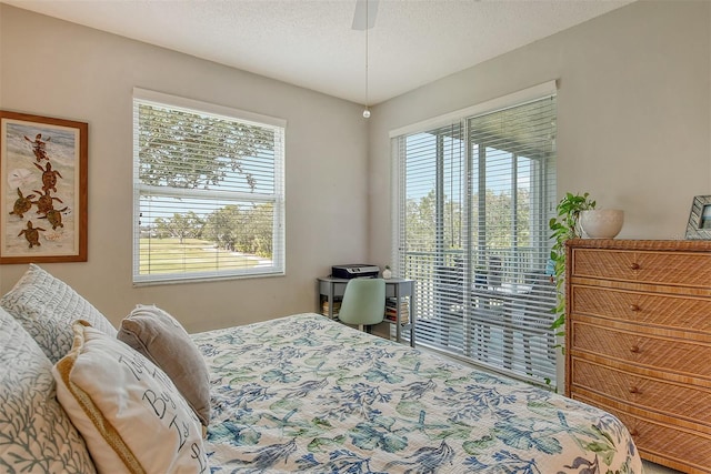 bedroom featuring ceiling fan, access to outside, and a textured ceiling