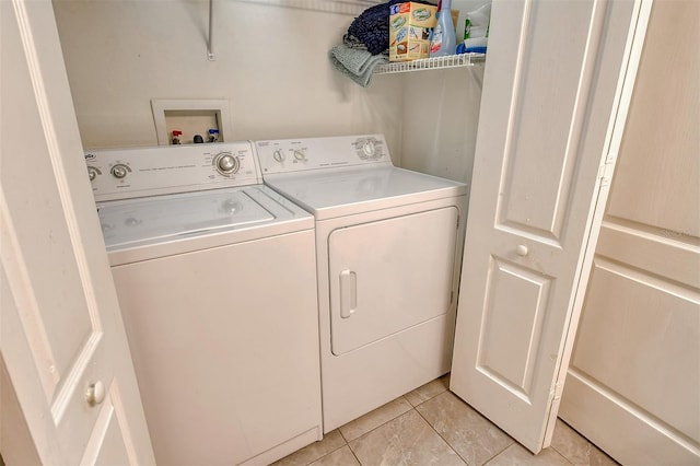 washroom with washer and clothes dryer and light tile patterned floors