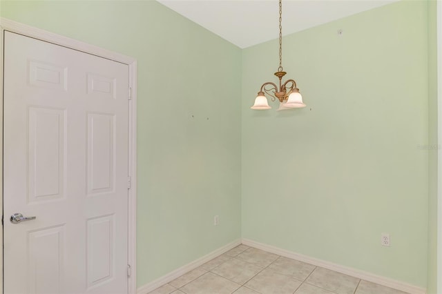 unfurnished dining area featuring light tile patterned floors and a notable chandelier