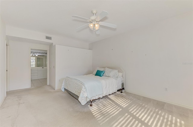 bedroom featuring ceiling fan, ensuite bathroom, and light carpet