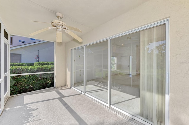 unfurnished sunroom with ceiling fan