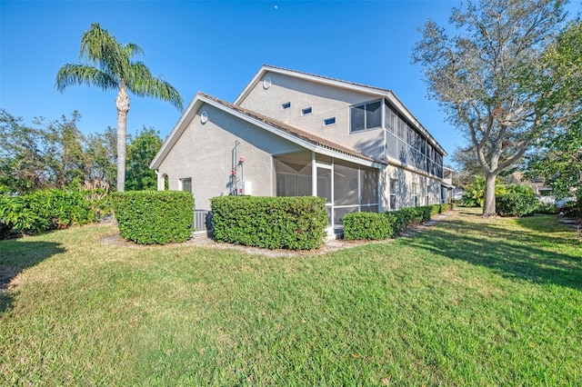 view of property exterior featuring a sunroom, cooling unit, and a lawn