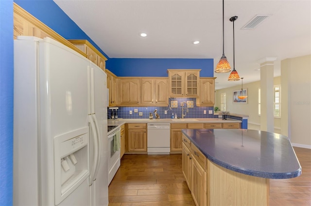 kitchen with sink, white appliances, a center island, and light brown cabinets