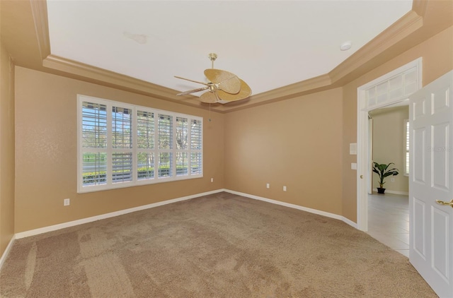 carpeted spare room featuring ceiling fan, ornamental molding, and a tray ceiling