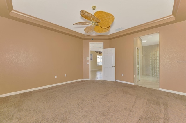 carpeted spare room featuring crown molding, ceiling fan, and a tray ceiling