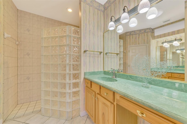 bathroom with vanity, tiled shower, and tile patterned floors