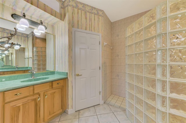 bathroom featuring tile patterned flooring, vanity, and tiled shower