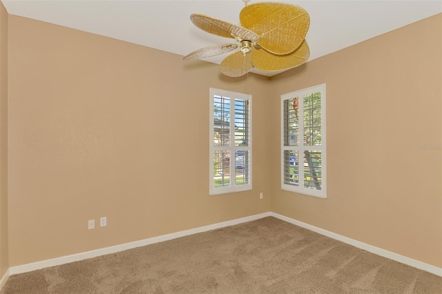 unfurnished room with ceiling fan and carpet