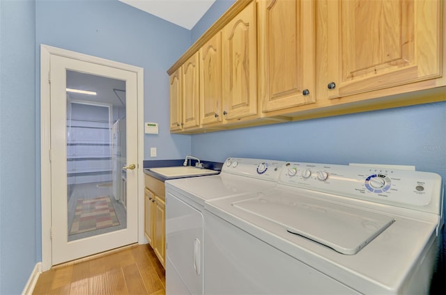 laundry area with sink, cabinets, independent washer and dryer, and light wood-type flooring