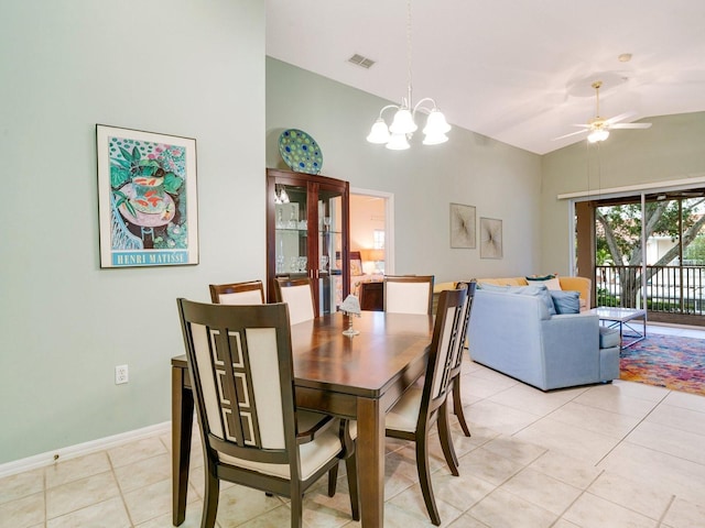 dining space featuring vaulted ceiling, ceiling fan with notable chandelier, and light tile patterned flooring