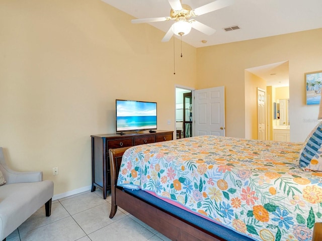 bedroom with ceiling fan, light tile patterned floors, and ensuite bath