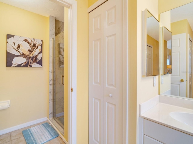 bathroom with tile patterned floors, walk in shower, and vanity