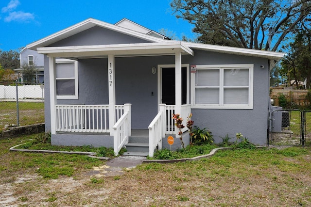 bungalow-style house with a front lawn and a porch