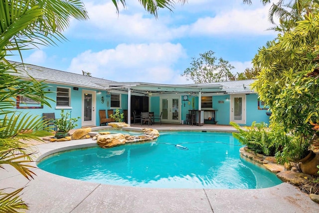 view of pool featuring french doors, a patio area, and a pool with connected hot tub