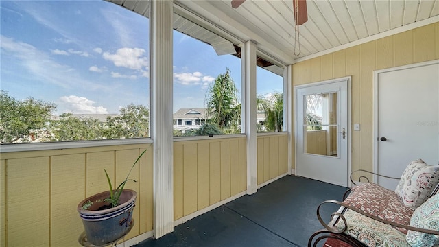 unfurnished sunroom featuring ceiling fan