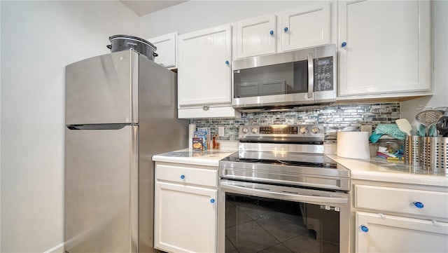 kitchen with stainless steel appliances, white cabinetry, and backsplash