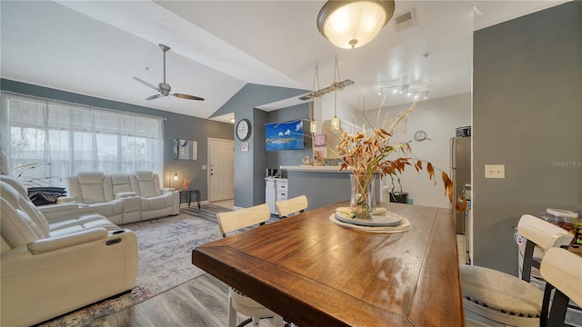 dining room featuring ceiling fan, lofted ceiling, and light hardwood / wood-style floors