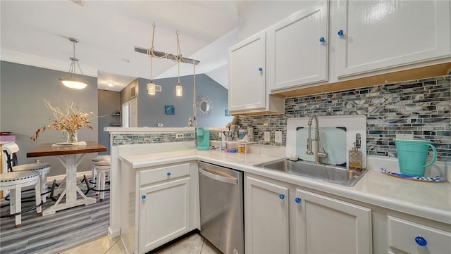 kitchen featuring hanging light fixtures, dishwasher, sink, and white cabinets