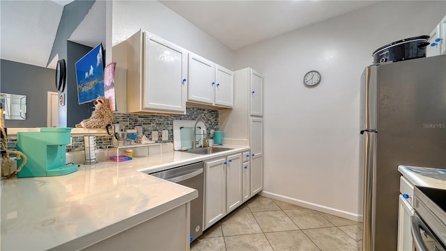 kitchen with sink, light tile patterned floors, appliances with stainless steel finishes, white cabinetry, and decorative backsplash