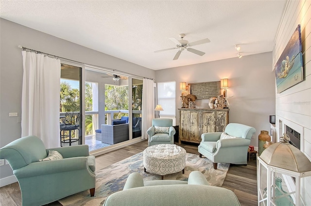 sitting room with hardwood / wood-style flooring, ceiling fan, and a textured ceiling