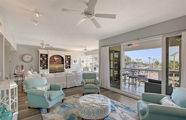 living room featuring hardwood / wood-style floors, a textured ceiling, and ceiling fan