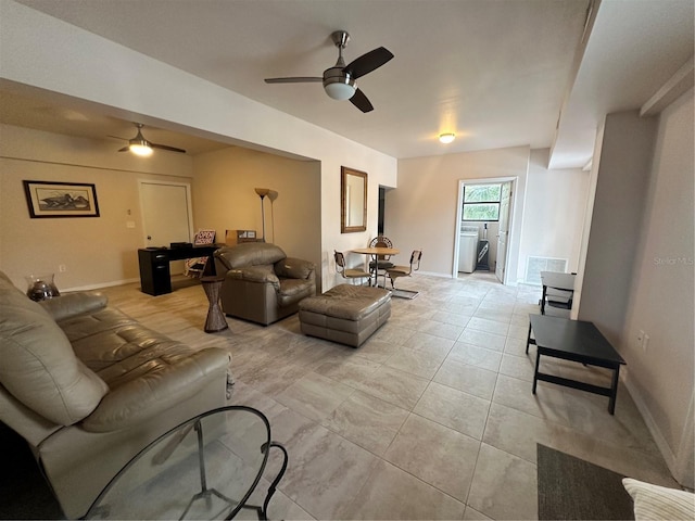 tiled living room featuring ceiling fan and washer / clothes dryer