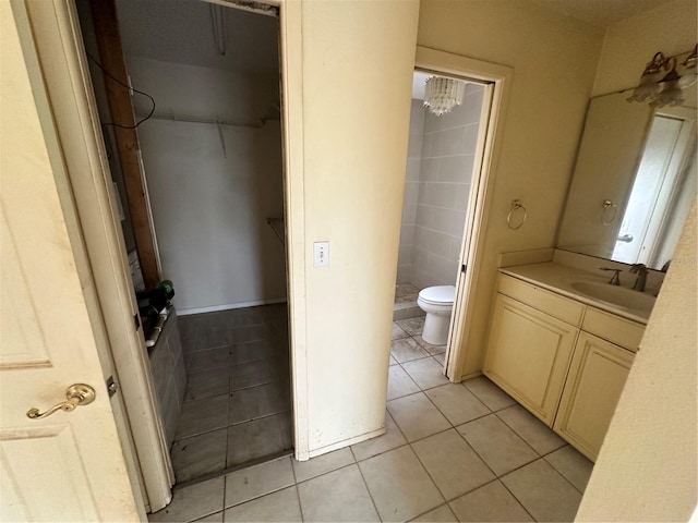 bathroom with vanity, toilet, a shower, and tile patterned floors