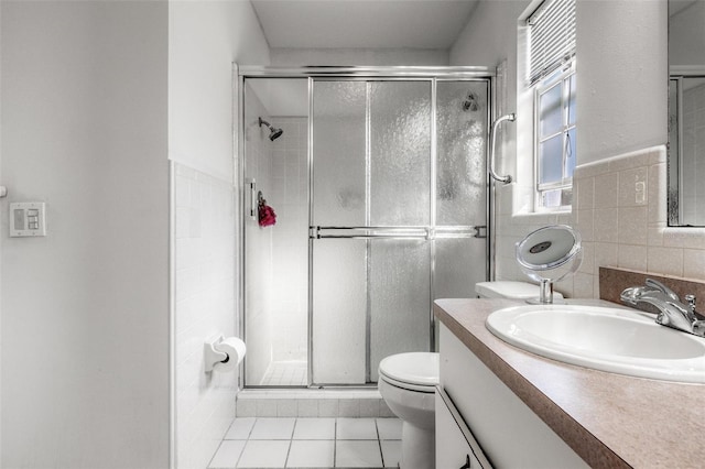 807 62nd St W, Bradenton, FL 34209 - full bathroom with toilet, vanity, a stall shower, tile patterned flooring, and tile walls