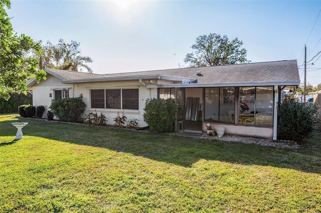 807 62nd St W, Bradenton, FL 34209 - rear view of property with a sunroom, a yard, and stucco siding