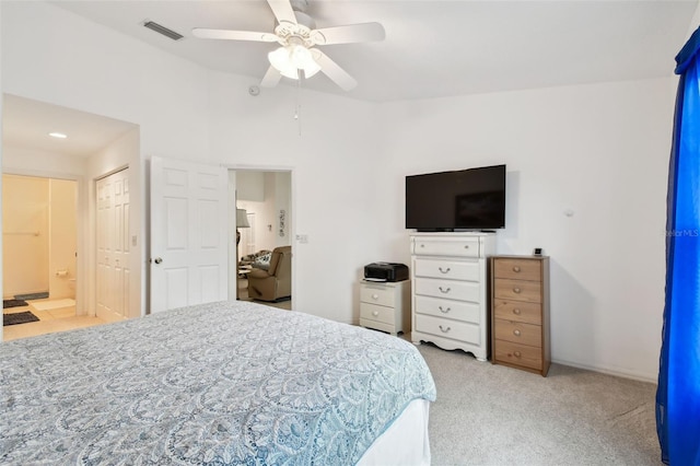 carpeted bedroom featuring a closet, connected bathroom, and ceiling fan