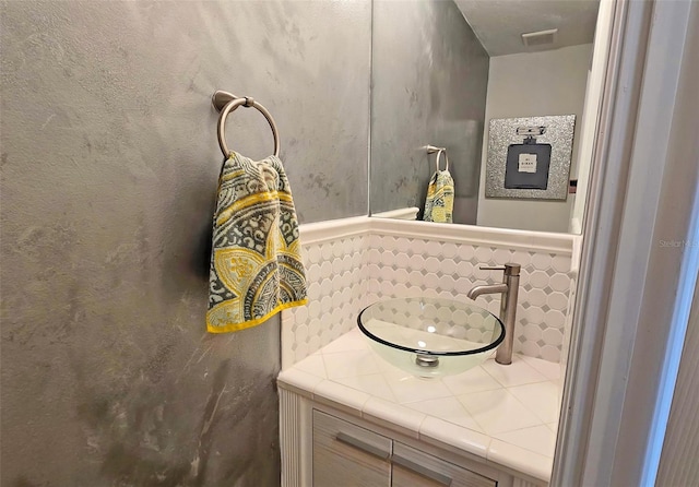 bathroom with vanity and decorative backsplash